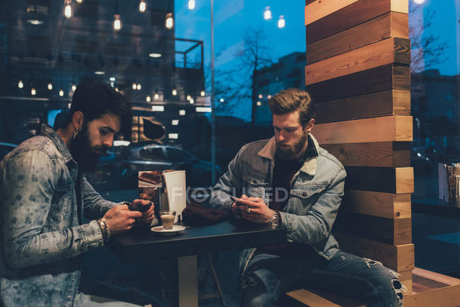 Hipster al caffè marciapiede guardando gli smartphone — Foto stock