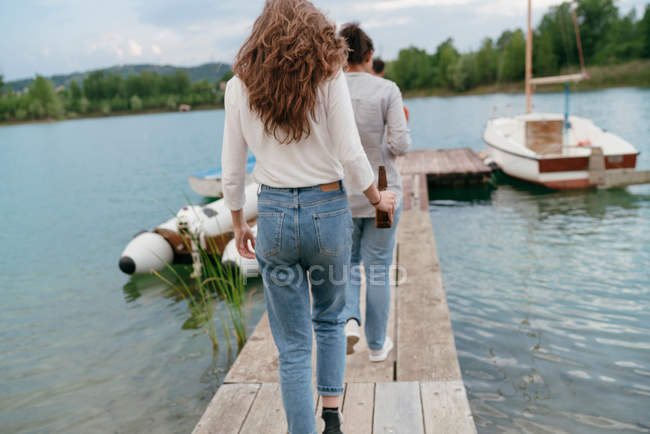 Freunde zu Fuß entlang der Seebrücke — Stockfoto
