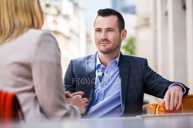 Businessman and businesswoman at sidewalk cafe — Stock Photo