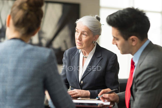 Бізнесмен обговорює з колегами-жінками — стокове фото