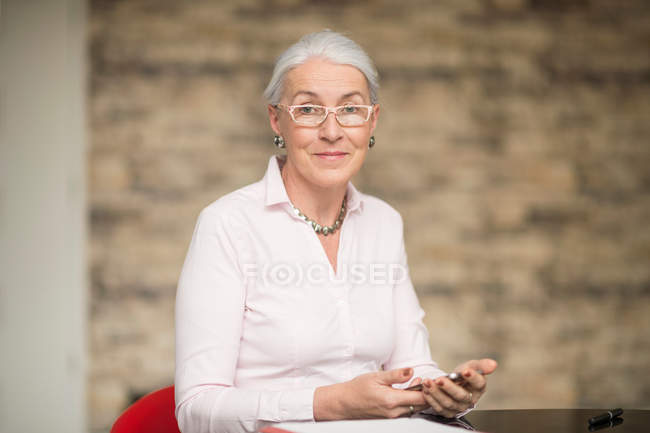 Mulher de negócios madura na mesa de escritório — Fotografia de Stock