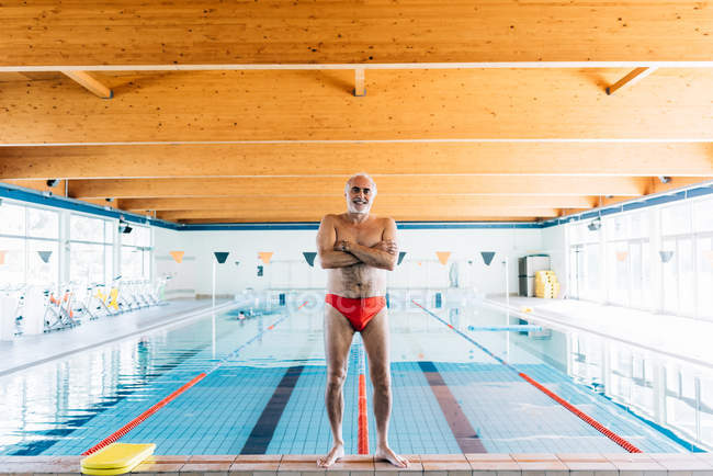 Homme debout près de la piscine — Photo de stock