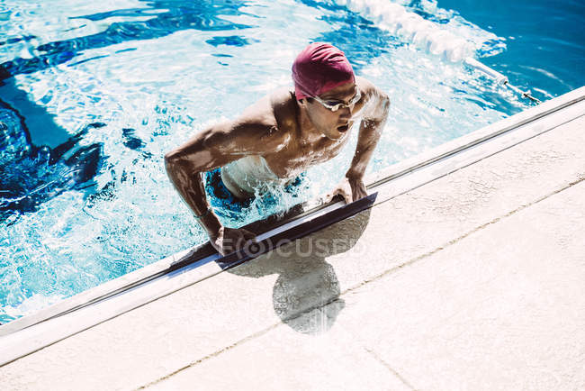 Swimmer climbing out of pool — Stock Photo