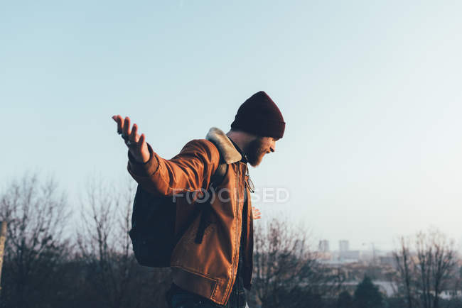Homme hipster en bonnet tricoté avec les bras ouverts — Photo de stock