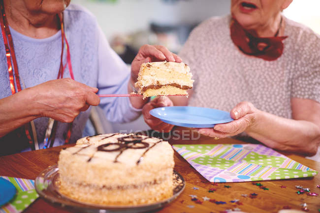Mulheres que servem bolo de aniversário — Fotografia de Stock