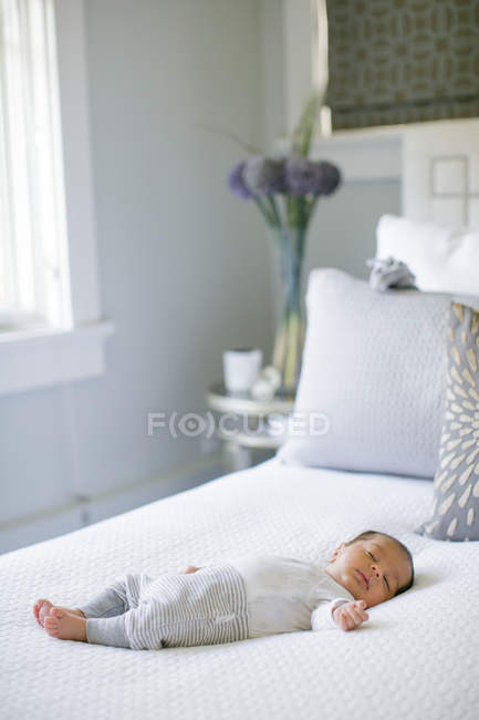 Bébé garçon, couché sur le lit — Photo de stock