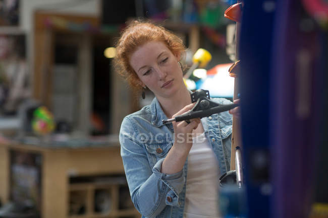 Femme travaillant dans un magasin de skateboard — Photo de stock