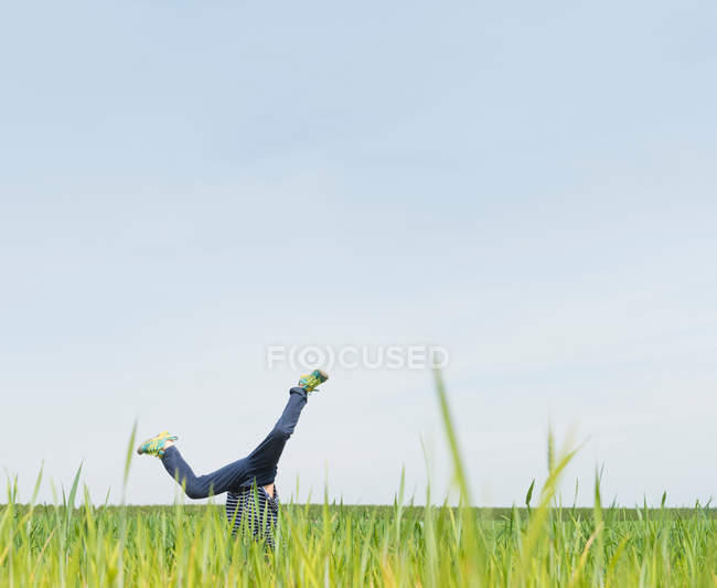Boy cartwheeling in grass — Stock Photo