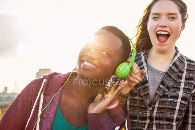 Hombre y mujer escuchando música de auriculares - foto de stock