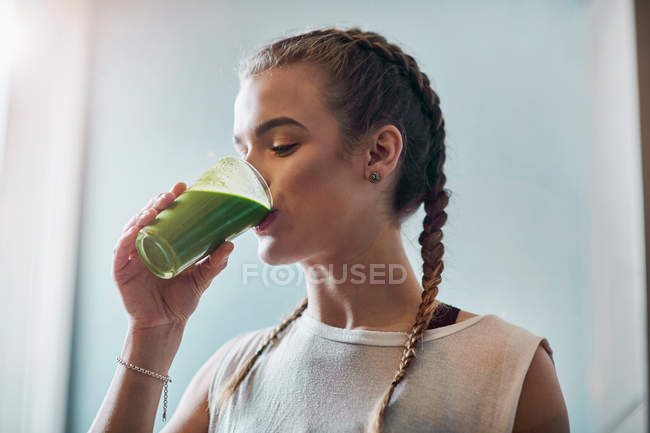 Женщина пьет овощной смузи — стоковое фото