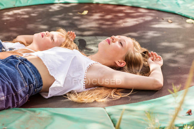 Meninas deitadas no trampolim — Fotografia de Stock