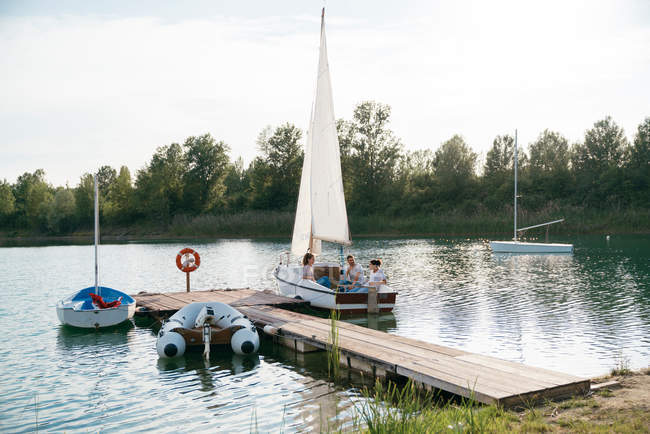Tre amici si rilassano in barca a vela — Foto stock