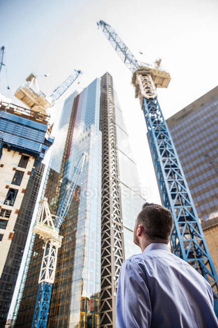 Homme d'affaires regardant vers le haut à la construction — Photo de stock