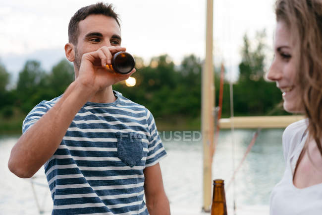 Man and woman with bottles of beer — Stock Photo