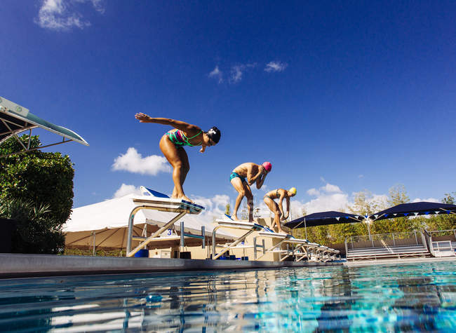 Swimmers on pool diving board — Stock Photo