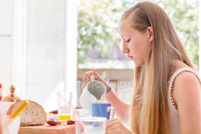 Teenage girl preparing breakfast — Stock Photo