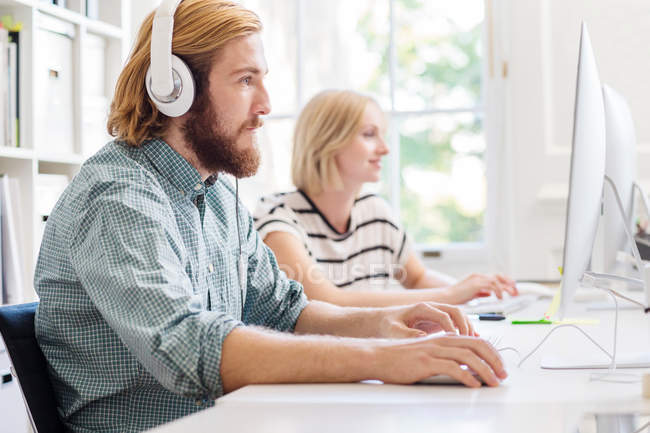 Designers listening to headphones — Stock Photo