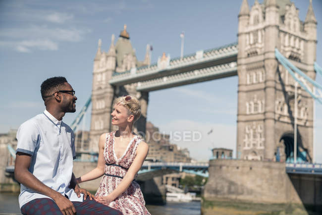 Young couple sitting on wall — Stock Photo