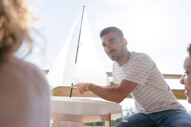 Hombre hablando a través de partes de barcos de vela - foto de stock