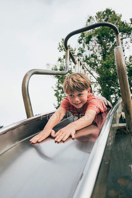 Boy sliding down slide — Stock Photo
