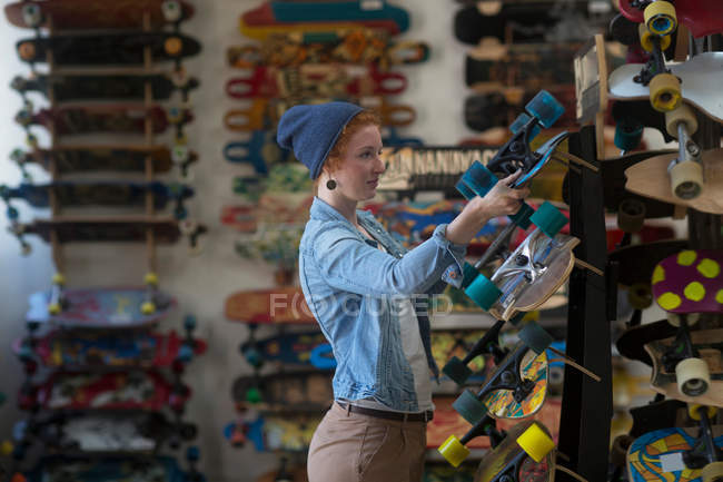 Mujer trabajando en una tienda de skate - foto de stock