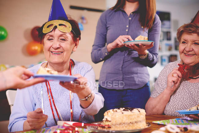 Mulheres sendo servido bolo de aniversário — Fotografia de Stock