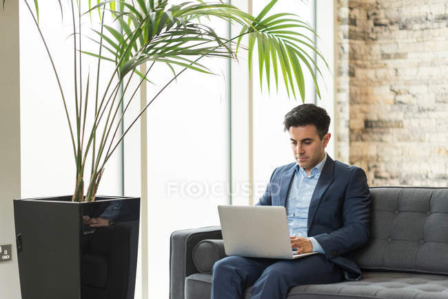 Бізнесмен сидить на офісному дивані — стокове фото