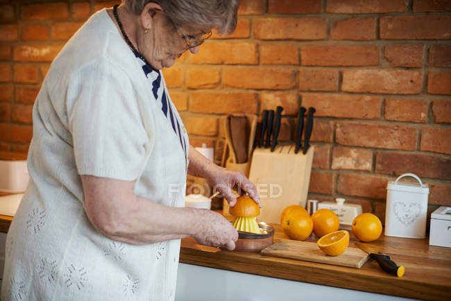 Жінка стискаючи апельсинів — стокове фото