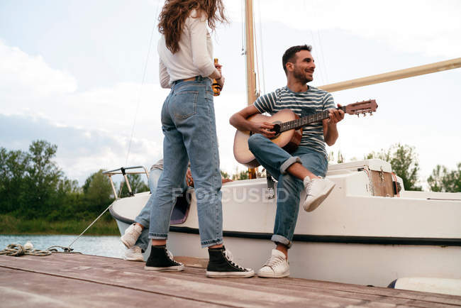 Mann spielt Gitarre auf Seebrücke — Stockfoto