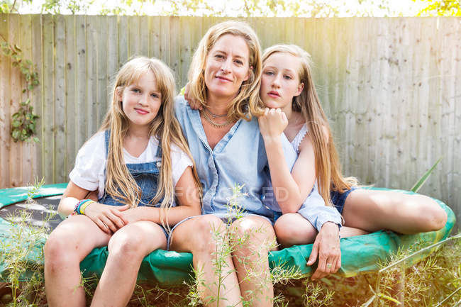 Mutter und Töchter sitzen auf Trampolin — Stockfoto