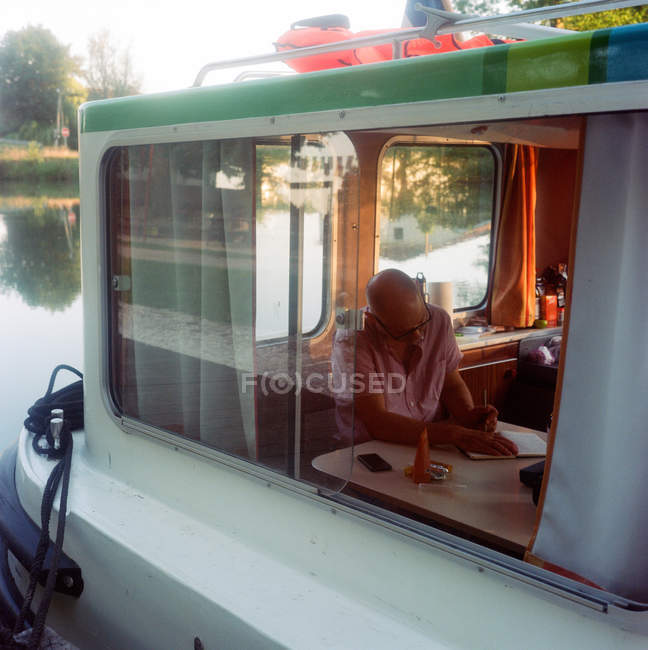 Mature man sitting inside barge — Stock Photo