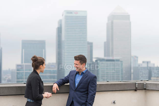 Businessman and female colleague on roof terrace — Stock Photo