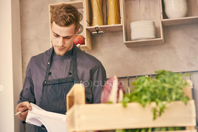 Chef olhando para a papelada — Fotografia de Stock