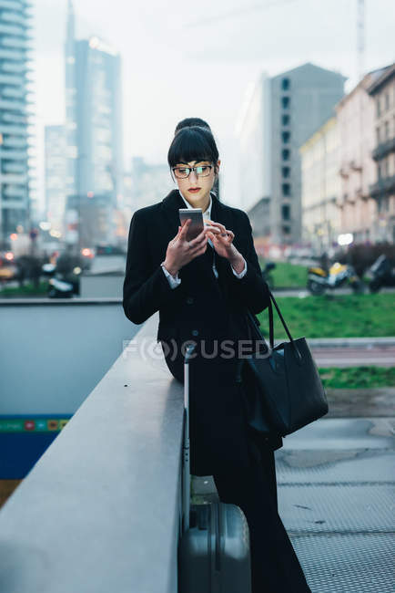 Businesswoman with trolley luggage — Stock Photo