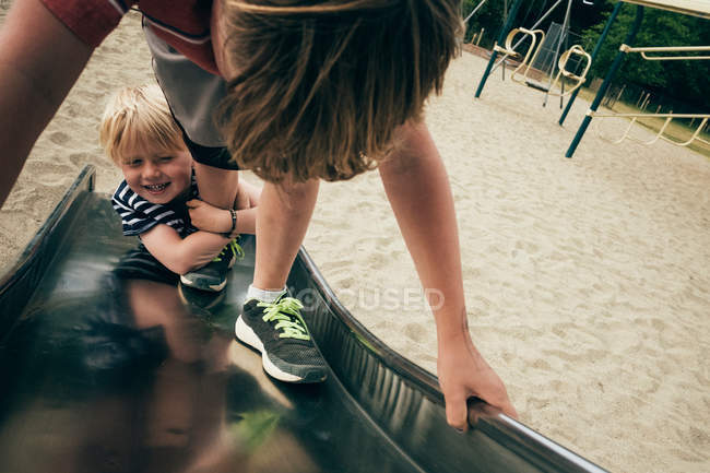 Boys playing on playground slide — Stock Photo
