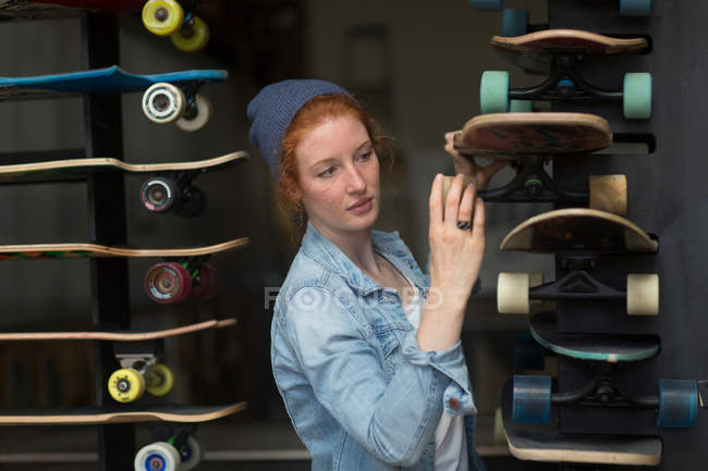 Woman working in skateboard shop — Stock Photo