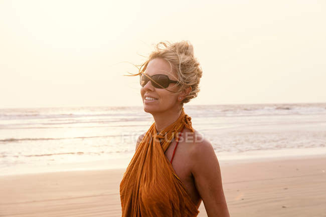 Жінка на пляжі дивиться геть — стокове фото