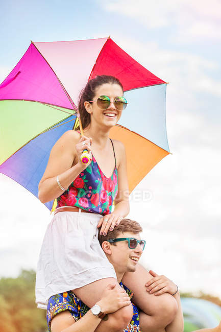 Uomo che trasporta donna con ombrello in mano — Foto stock