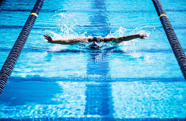 Nadadores fazendo golpe de borboleta na pista — Fotografia de Stock