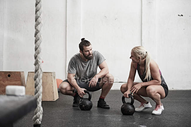 Couple with kettlebells in gym — Stock Photo