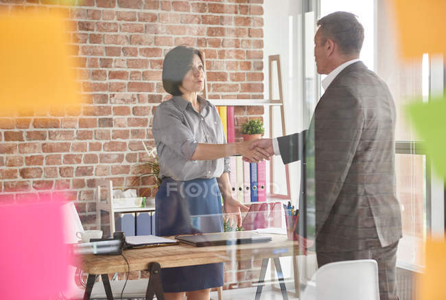 Business people in office shaking hands — Stock Photo