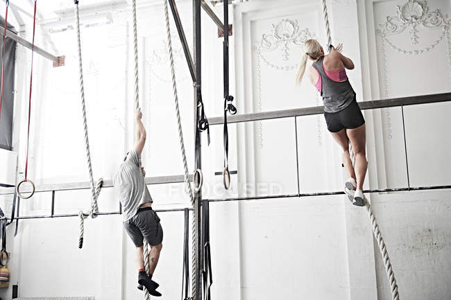 Escalada de corda de casal no ginásio — Fotografia de Stock