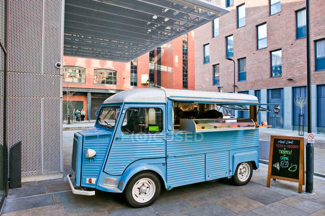 Vintage pizza van car parked outside office buildings — Stock Photo