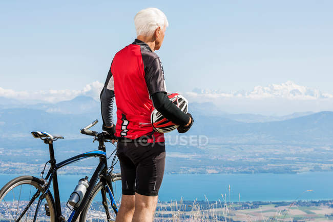 Старший мужчина рядом с велосипедом — стоковое фото