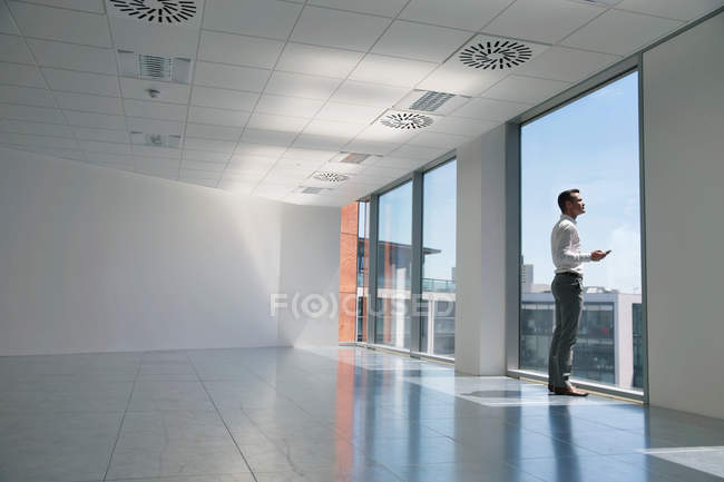 Businessman looking out of window — Stock Photo