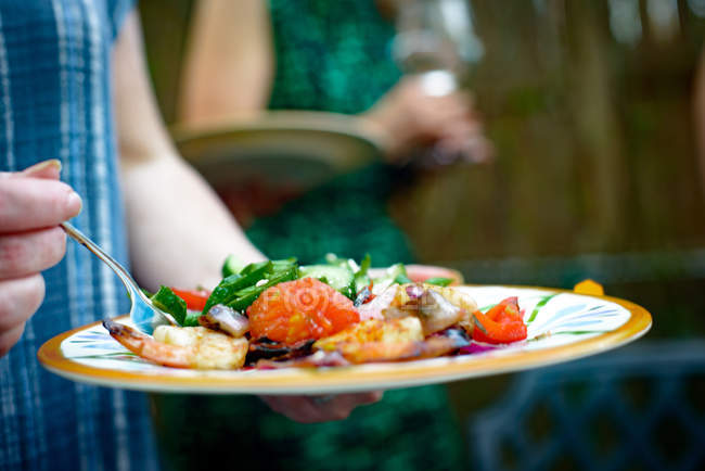 Руки женщины держат тарелку с овощами — стоковое фото