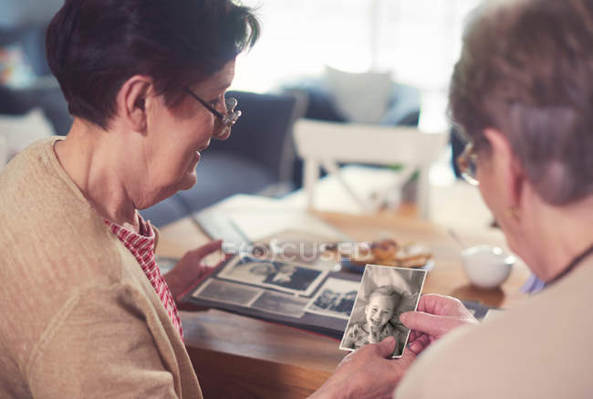 Women looking at old photographs — Stock Photo