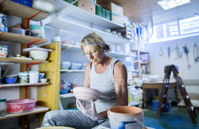 Старшая женщина в мастерской керамики — стоковое фото