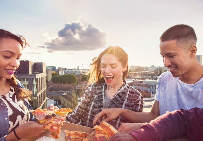 Jovens amigos adultos compartilhando pizza — Fotografia de Stock