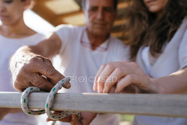 Мужчина показывает женщинам морской узел — стоковое фото